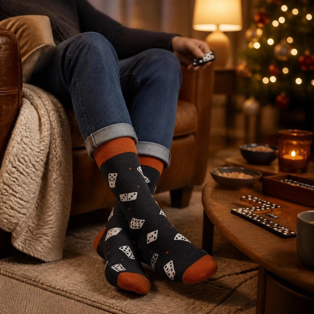 WearMoods Domino socks worn with rolled jeans by a cosy armchair, dominoes on the coffee table and a Christmas tree behind