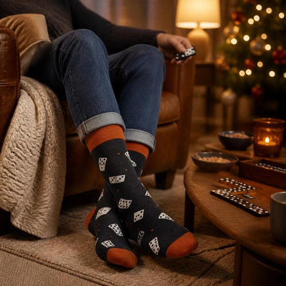 WearMoods Domino socks worn with rolled jeans by a cosy armchair, dominoes on the coffee table and a Christmas tree behind